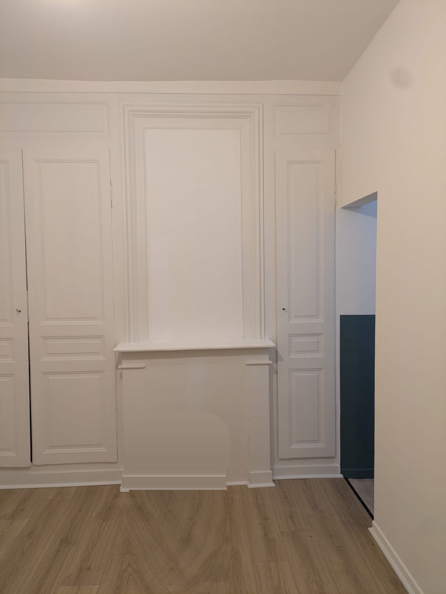 Boiseries repeintes en blanc avec mur d'accent bleu canard